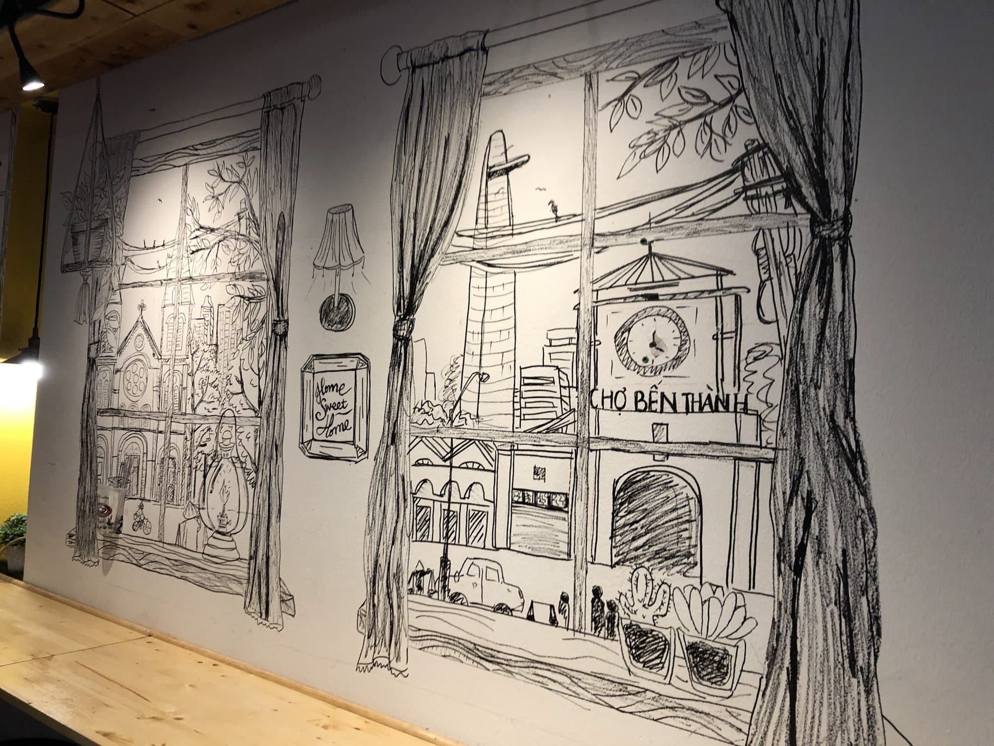 Black line drawing mural of a window looking out at Chợ Bến Thành market in Saigon
