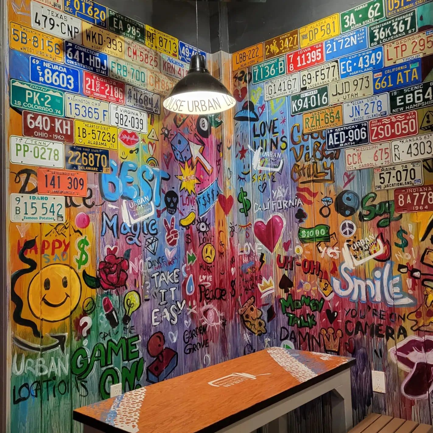 Close view of the painted license plate wall with smiley faces and lettering