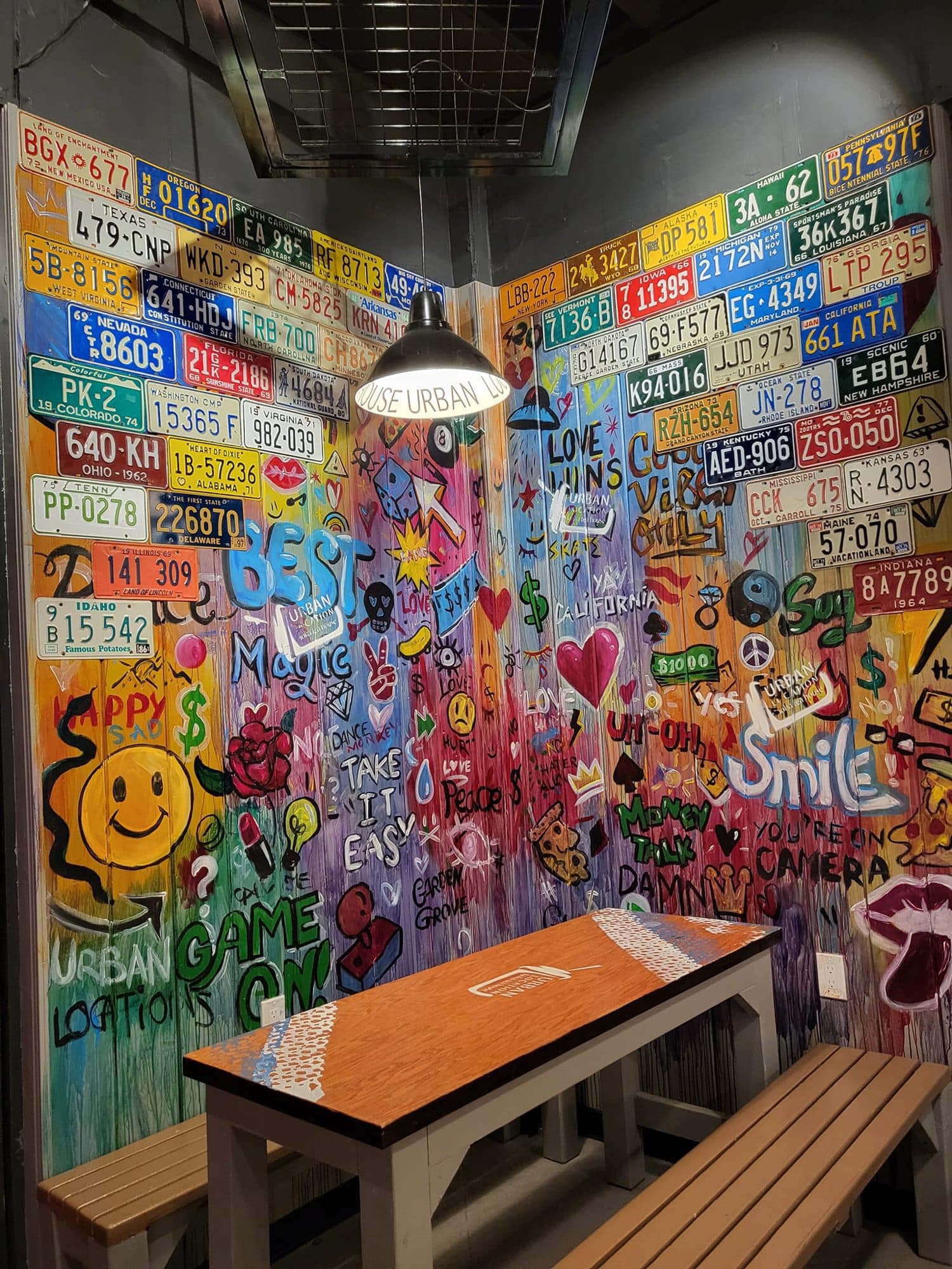 Colorful pop-art painted license plate wall in a restaurant corner