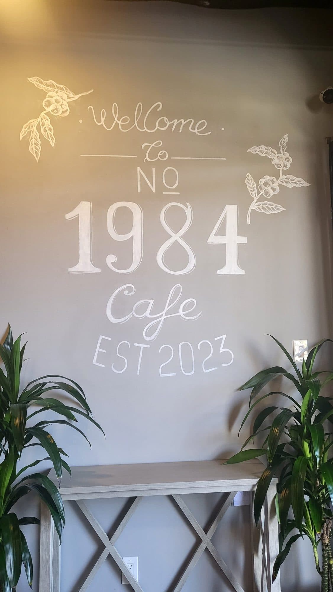 Hand-lettered Welcome to No 1984 Cafe Est 2023 wall with coffee branch drawings