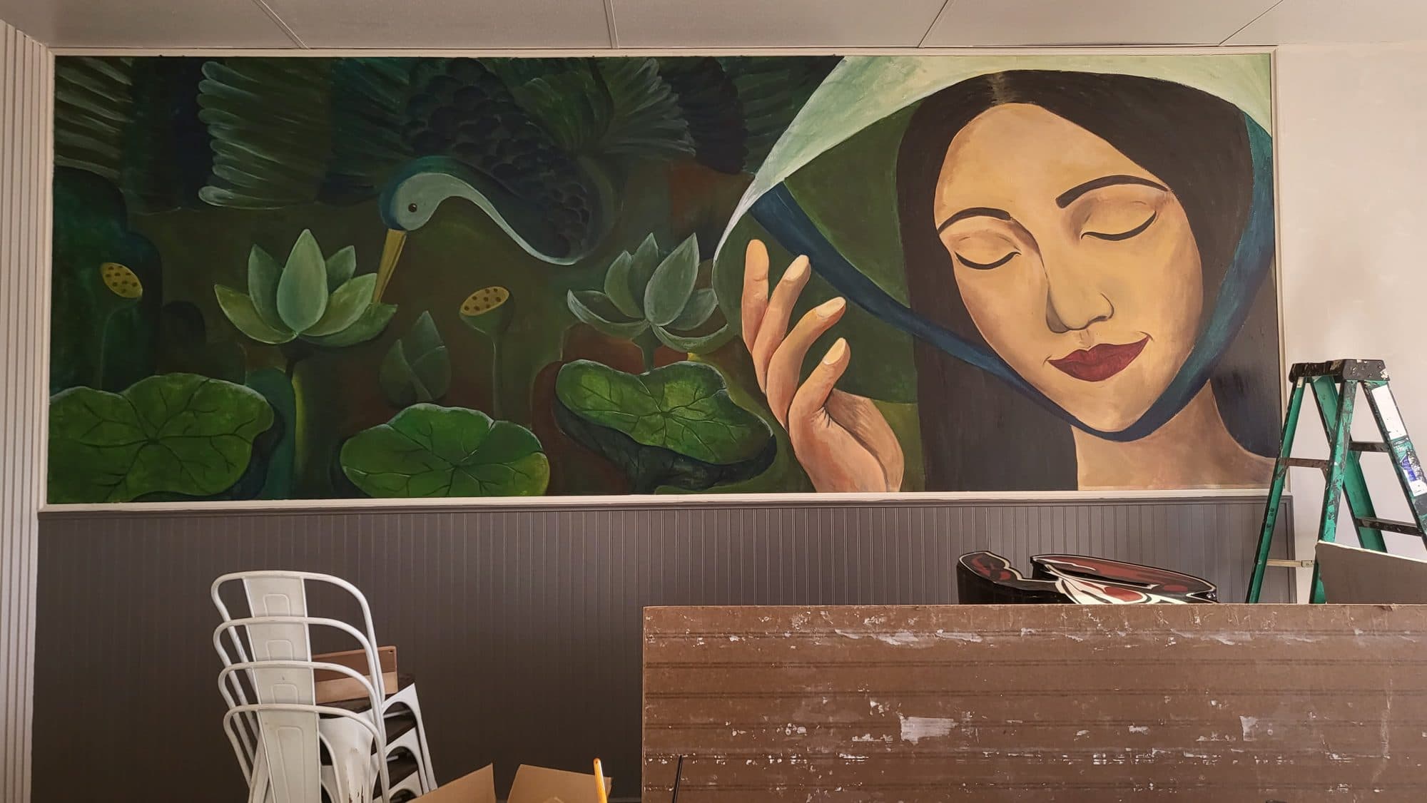 Mural of a Vietnamese woman holding a nón lá conical hat beside a lotus pond