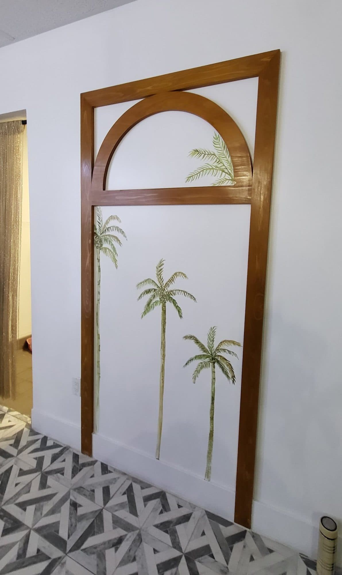 Painted palm trees inside a wooden arched doorway frame