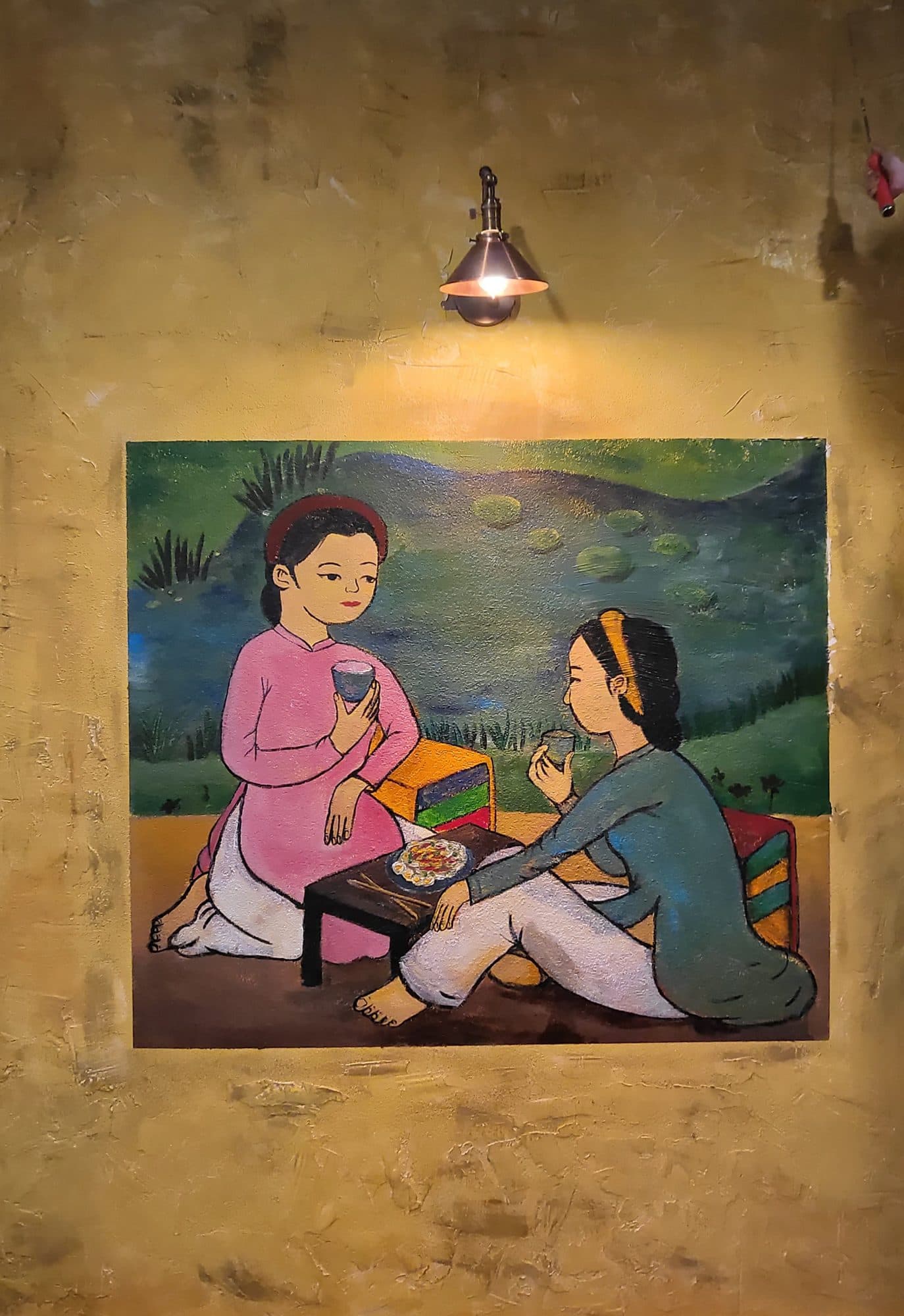 Painting of two Vietnamese girls in áo dài sitting by the water